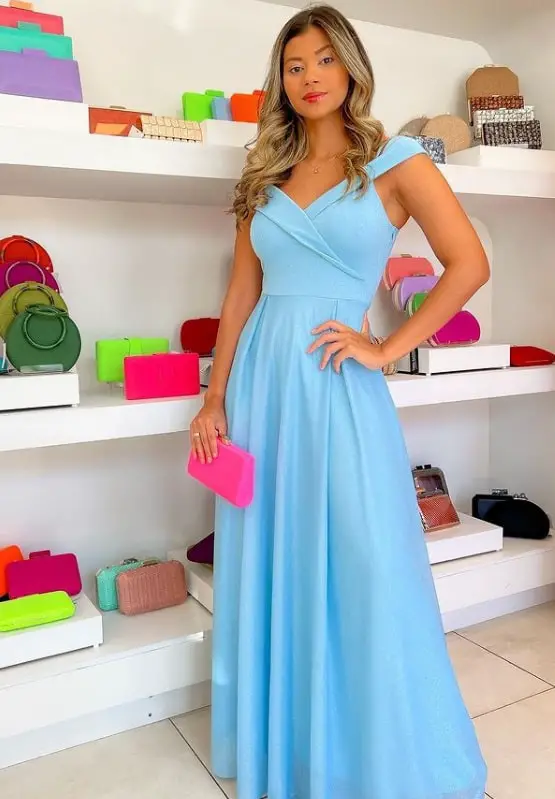 Woman in a blue dress with a pink purse