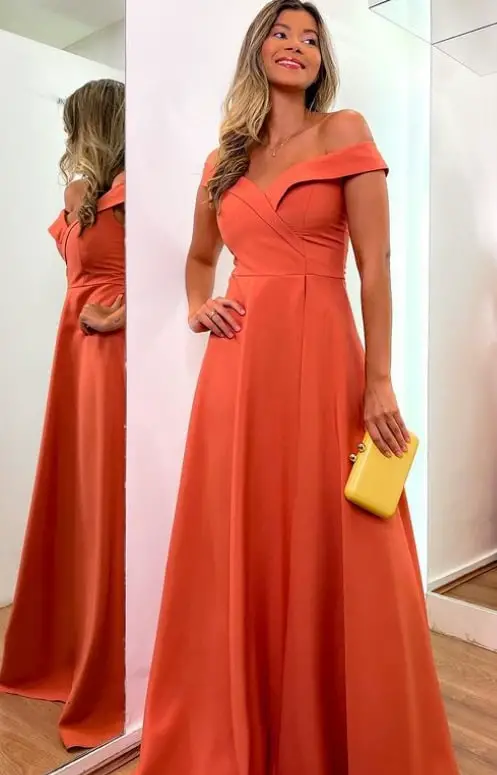 Woman in terracotta dress with a yellow clutch bag