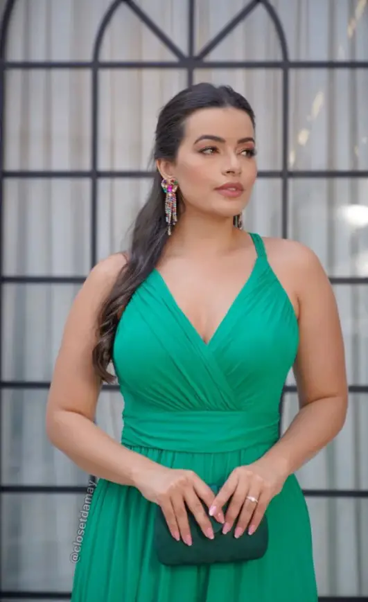 Woman in green dress with an emerald green clutch bag