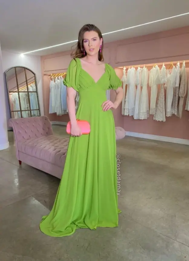 Woman in a green dress with a salmon clutch
