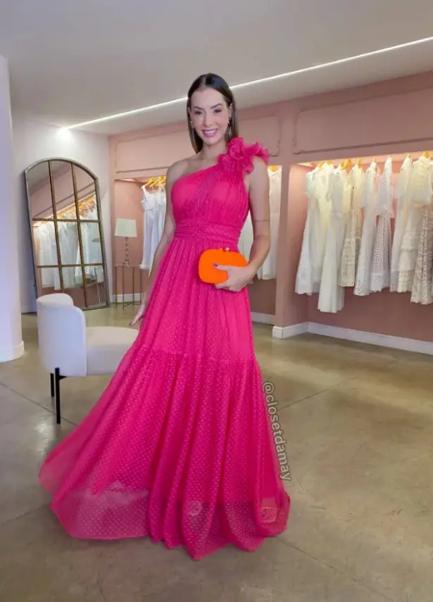 Woman in a pink dress with a coral clutch bag