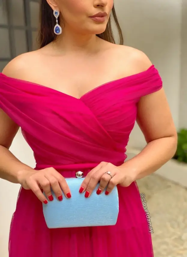 Woman in a pink dress with a light blue clutch bag