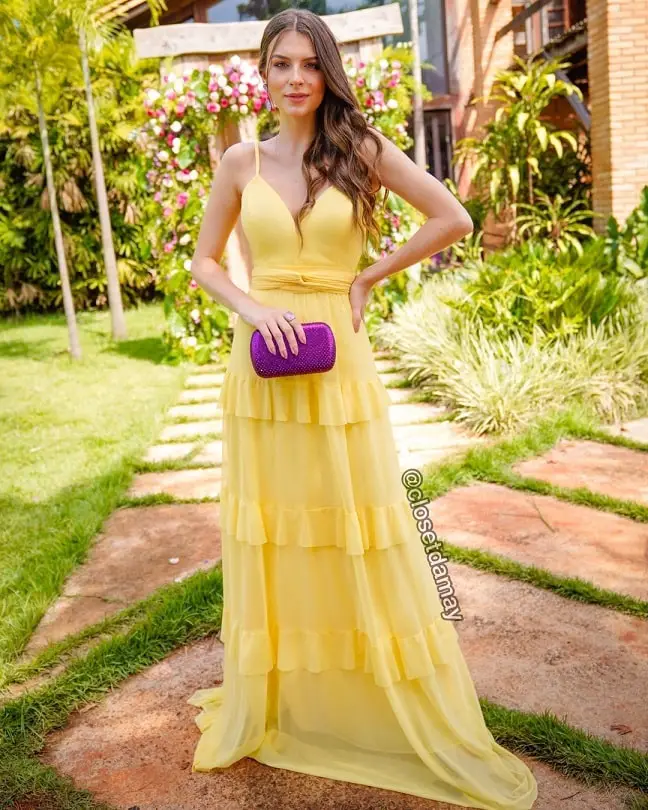 Yellow dress with a purple clutch bag