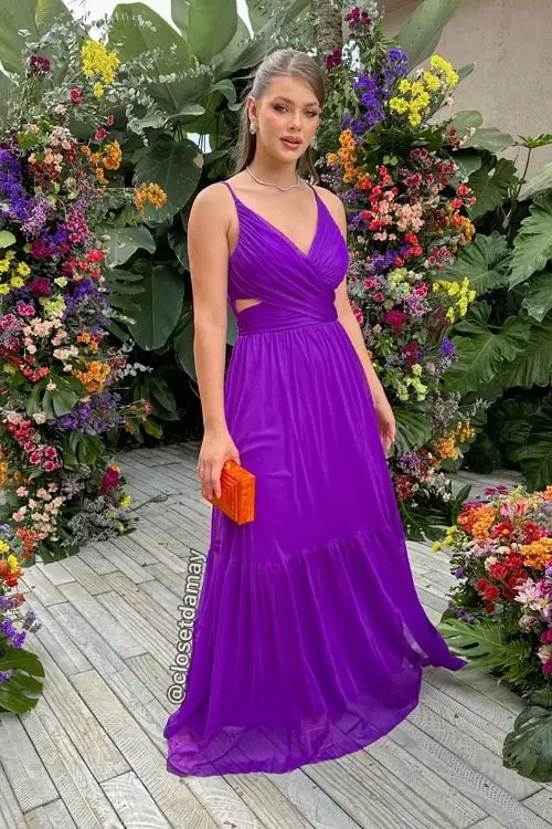 Purple dress with orange clutch bag